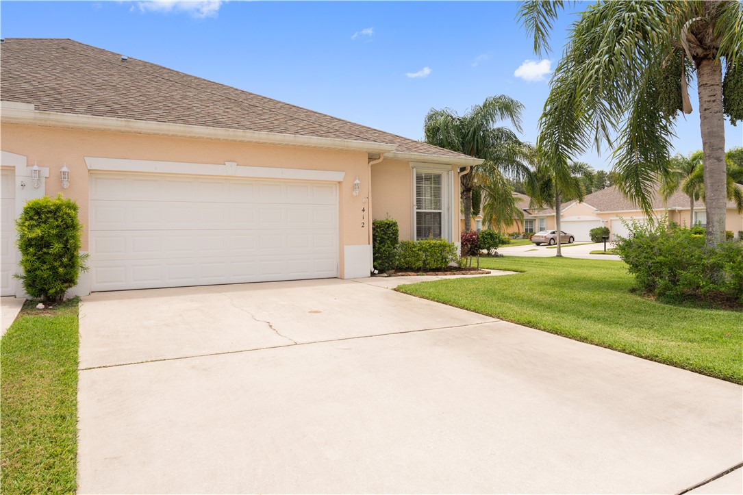 412 North Tangerine Square Southwest Vero Beach, FL 32968 - Photo 26 of 35 a view of a house with a yard and palm trees