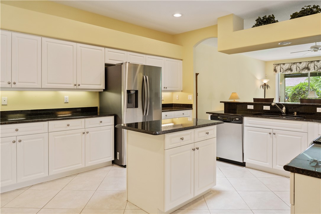 412 North Tangerine Square Southwest Vero Beach, FL 32968 - Photo 7 of 35 a kitchen with granite countertop white cabinets and white appliances