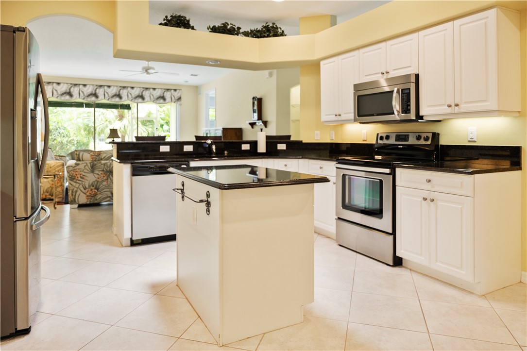412 North Tangerine Square Southwest Vero Beach, FL 32968 - Photo 8 of 35 a kitchen with stainless steel appliances granite countertop a stove top oven a sink a counter top space and cabinets