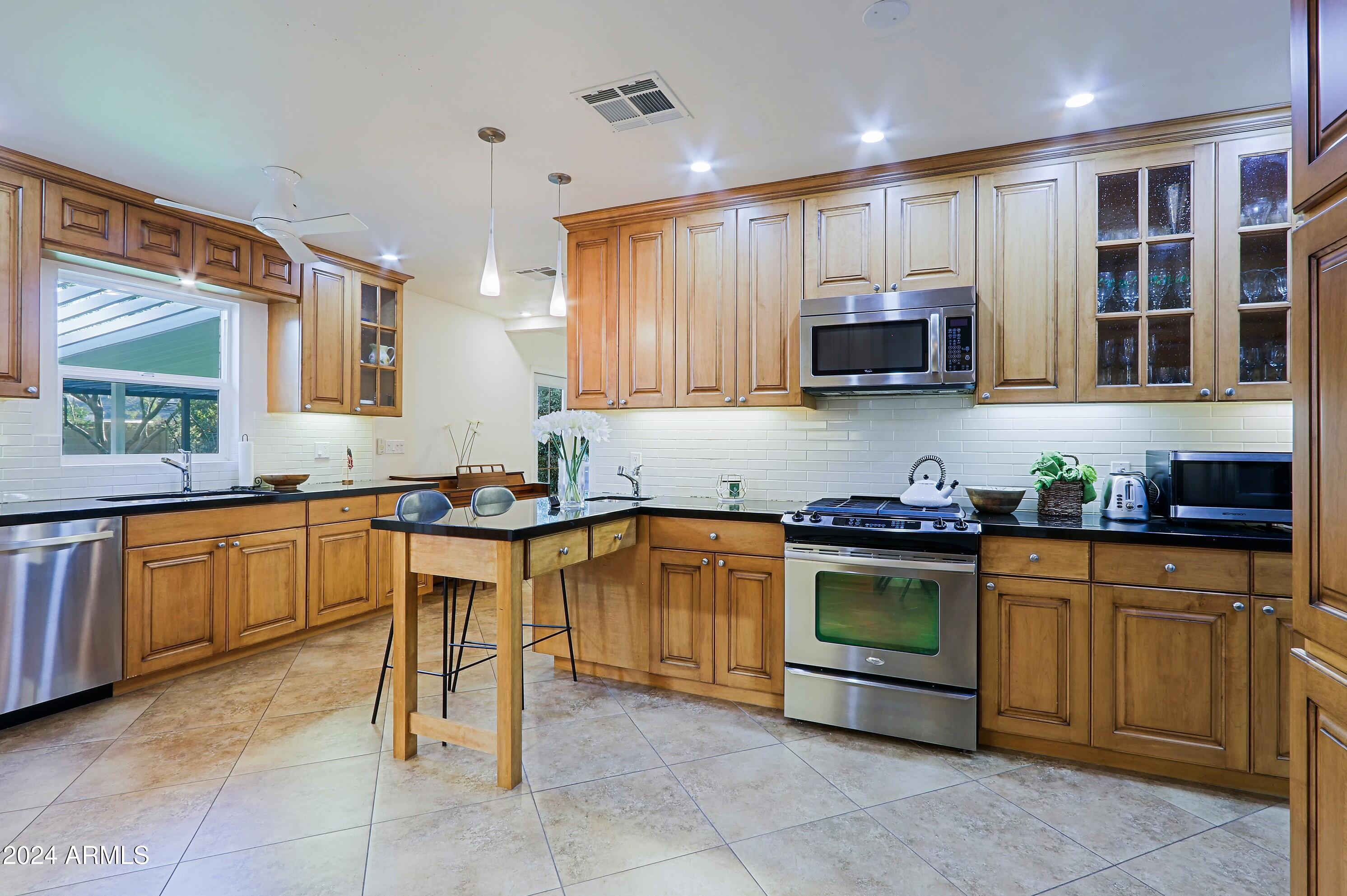 4645 East Windsor Avenue Phoenix, AZ 85008 - Photo 11 of 33 a kitchen with stainless steel appliances granite countertop a stove sink and microwave