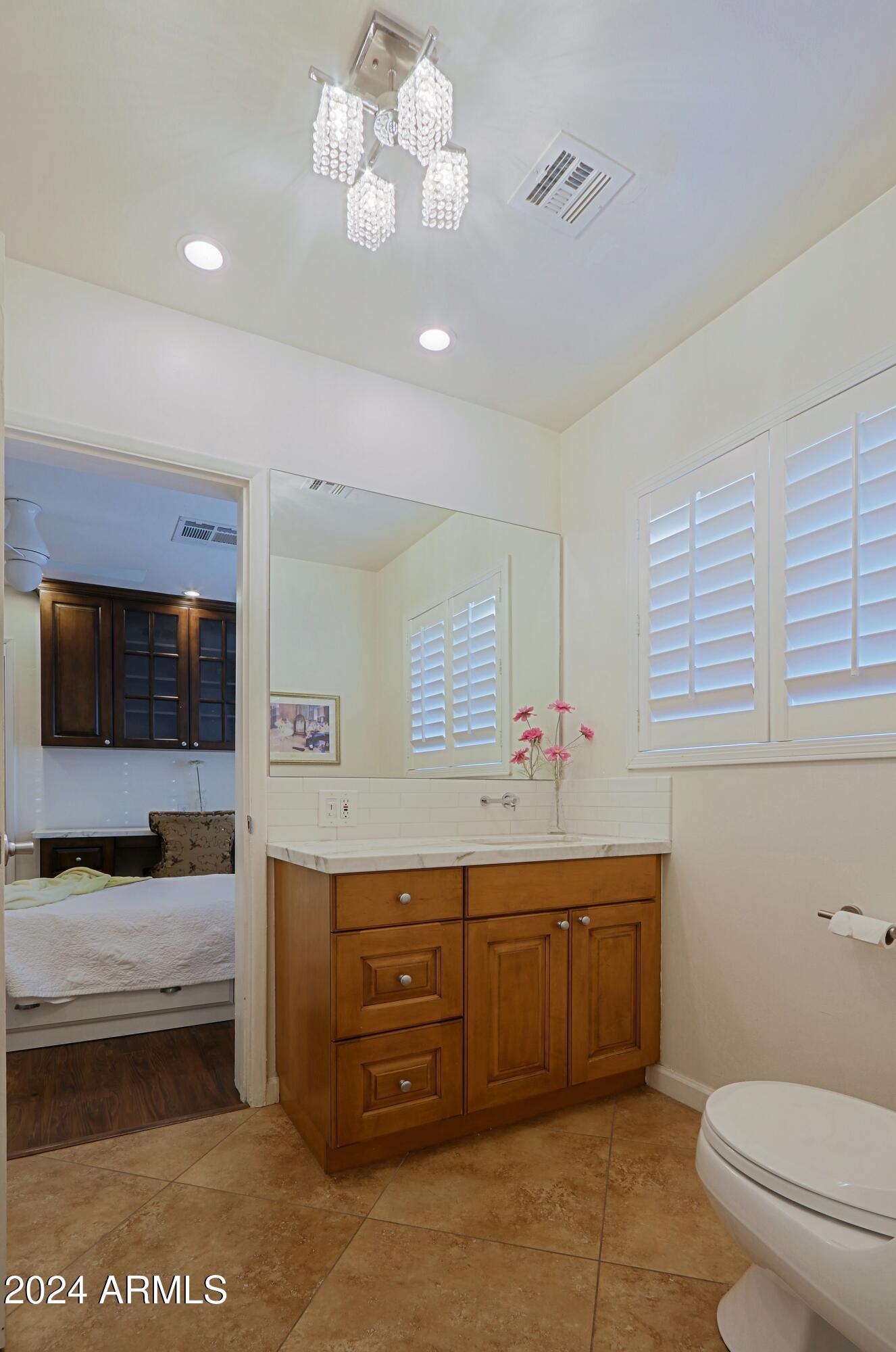 4645 East Windsor Avenue Phoenix, AZ 85008 - Photo 27 of 33 a spacious bathroom with a sink a large mirror and a toilet