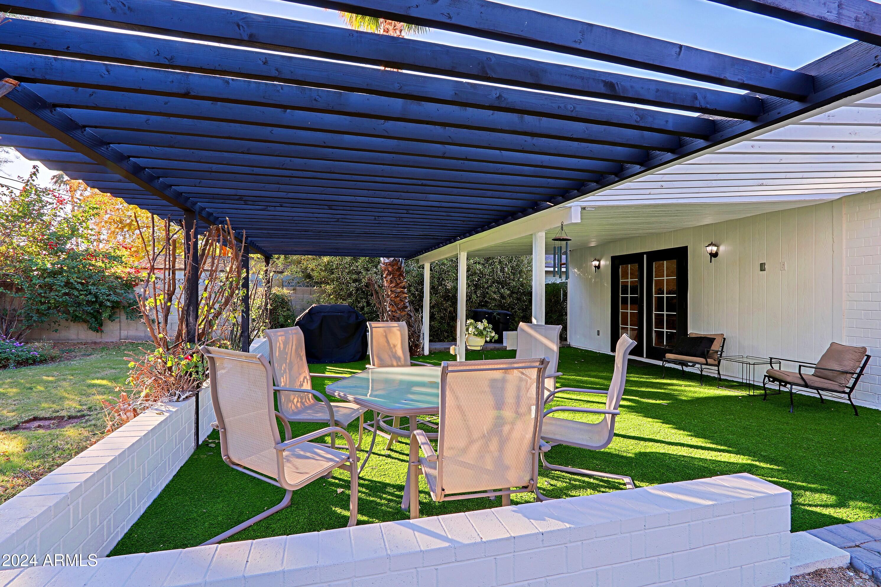 4645 East Windsor Avenue Phoenix, AZ 85008 - Photo 29 of 33 a view of a chair and tables in the patio next to a yard