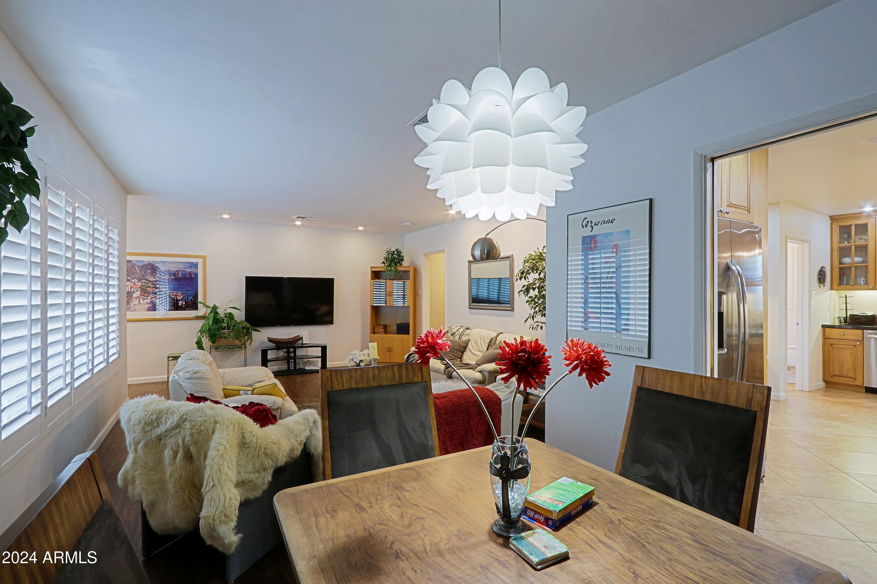 4645 East Windsor Avenue Phoenix, AZ 85008 - Photo 8 of 33 a living room with furniture flowers and a flat screen tv
