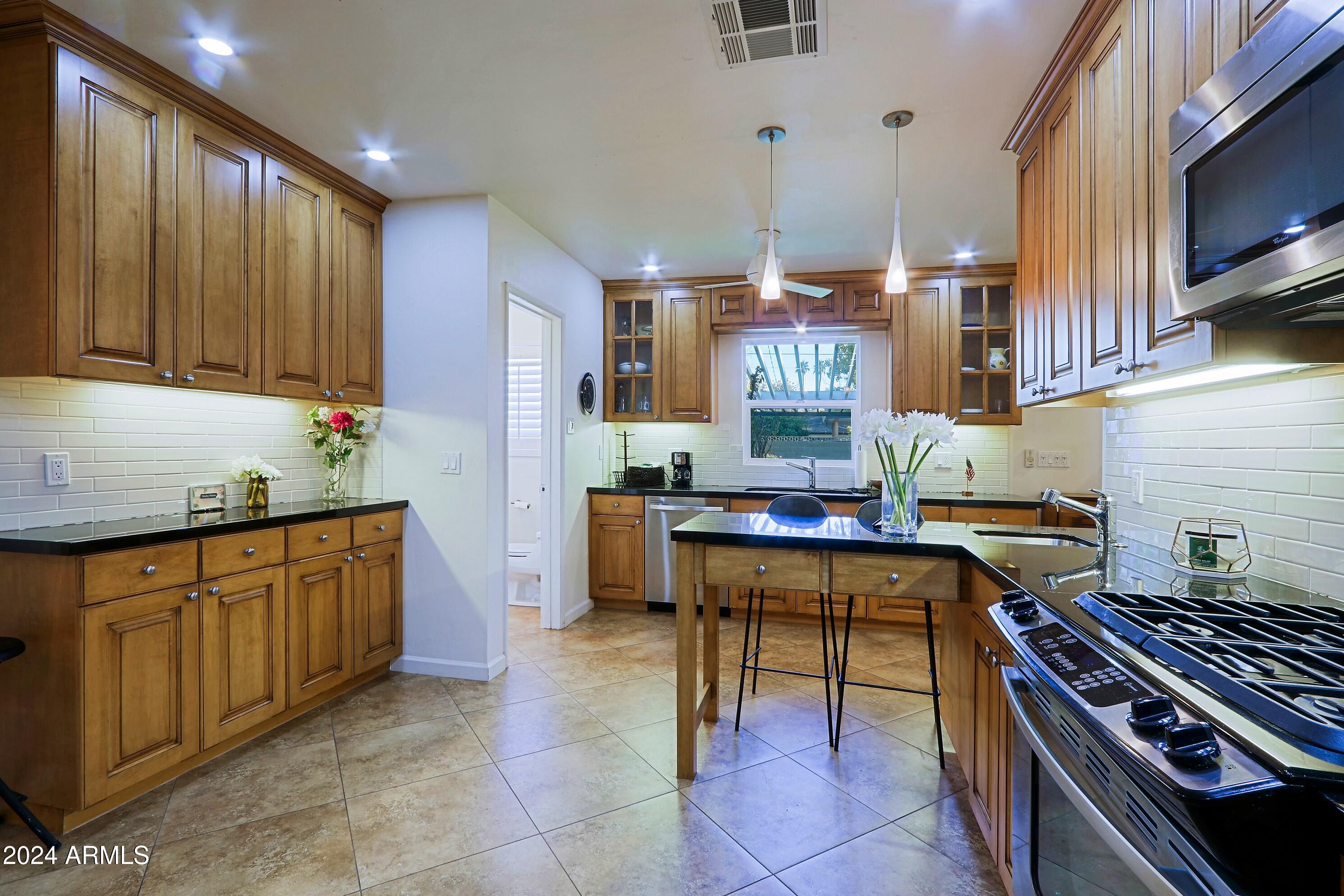 4645 East Windsor Avenue Phoenix, AZ 85008 - Photo 10 of 33 a kitchen with a sink stove and cabinets