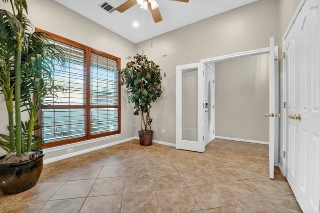 a view of an empty room with a potted plant and windows