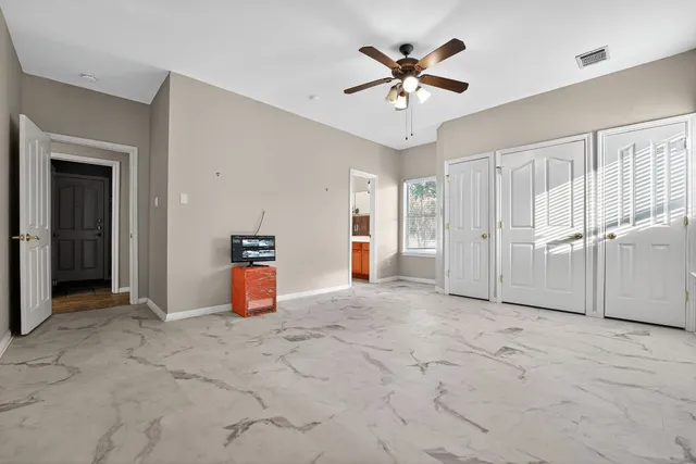 an empty room with closet and fan