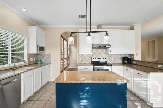a kitchen with stainless steel appliances granite countertop a sink stove and refrigerator