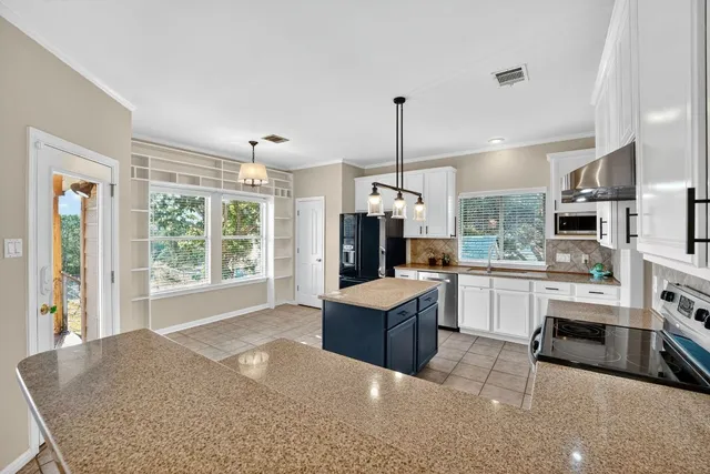 a open kitchen with cabinets and stainless steel appliances