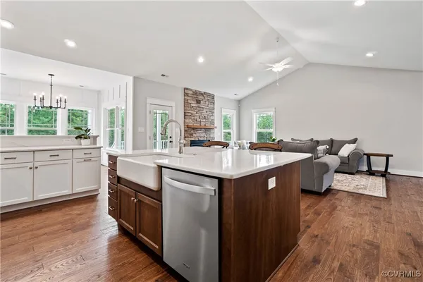a kitchen with kitchen island granite countertop a sink cabinets and wooden floor