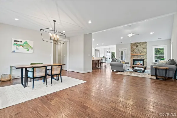 a view of a dining room and livingroom with furniture wooden floor a chandelier