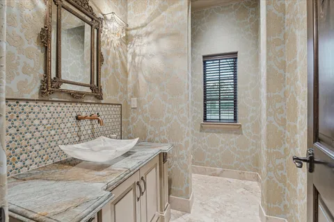 a bathroom with a granite countertop sink a mirror and shower