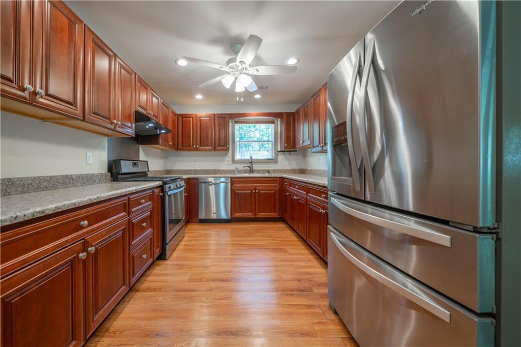 25 Quail Ridge Road Taylorsville, GA 30178 - Photo 11 of 29 a large kitchen with stainless steel appliances granite countertop a refrigerator a sink dishwasher a stove and white cabinets with wooden floor
