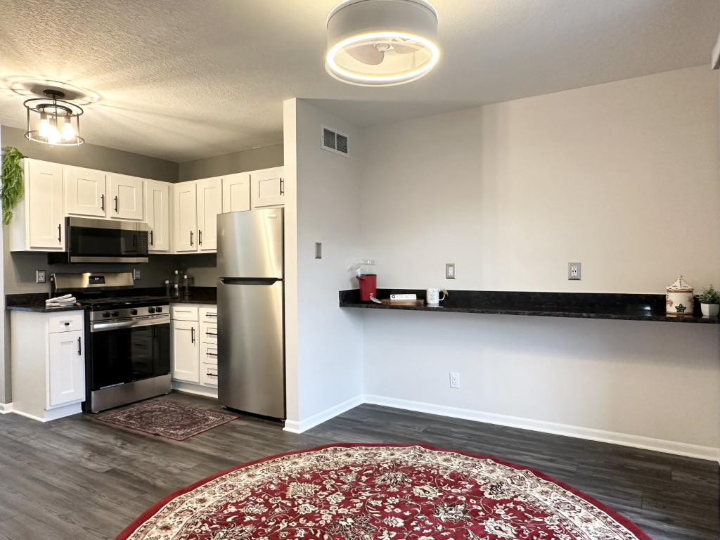 1514 Northfield Meadows Boulevard, Unit 2 Bourbonnais, IL 60914 - Photo 4 of 30 a kitchen with stainless steel appliances granite countertop a refrigerator a stove a sink and a microwave