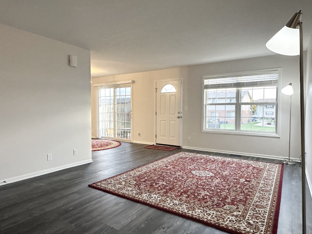 1514 Northfield Meadows Boulevard, Unit 2 Bourbonnais, IL 60914 - Photo 7 of 30 an empty room with wooden floor and windows