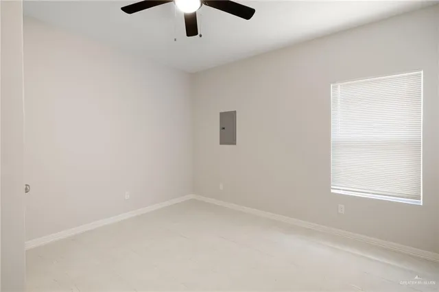 an empty room with a window and a fan