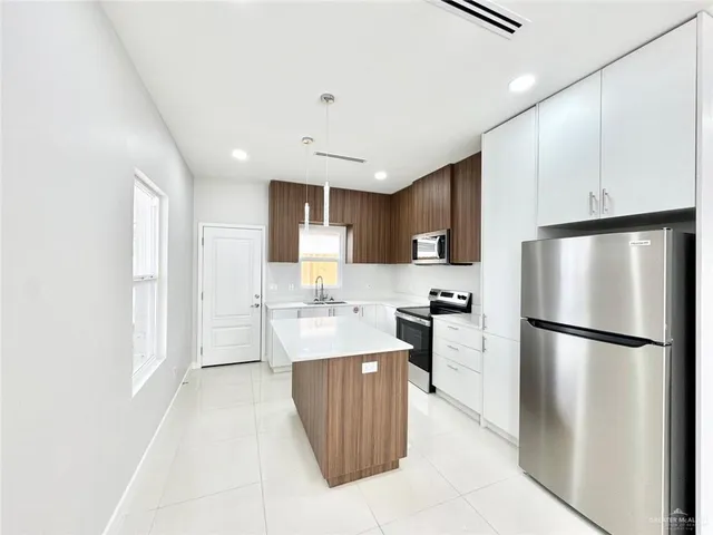 a kitchen with a refrigerator a stove top oven and a refrigerator