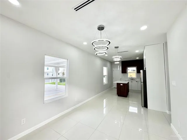 a view of a hallway that has a couch and a chandelier