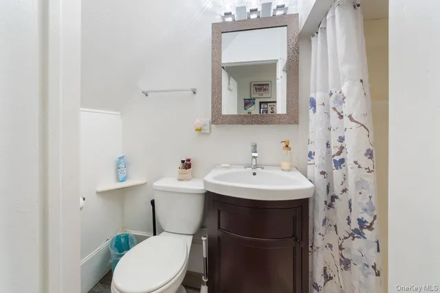 a bathroom with a sink toilet and mirror