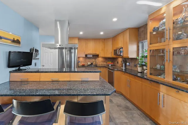 a kitchen with stainless steel appliances granite countertop a stove a sink and a refrigerator