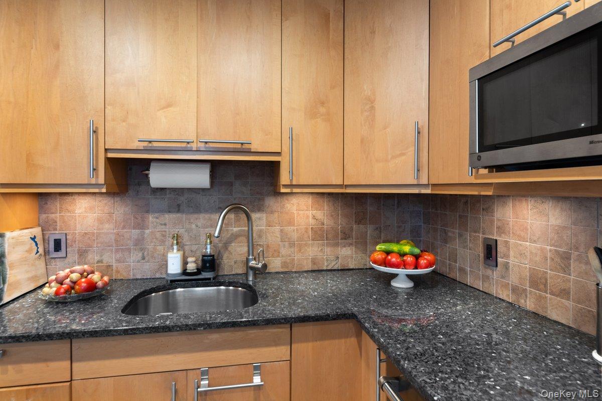 902 Dean Avenue Bronx, NY 10465 - Photo 37 of 40 a kitchen with stainless steel appliances granite countertop a sink dishwasher and cabinets with wooden floor