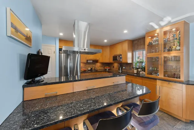 a kitchen with stainless steel appliances granite countertop a sink a stove and a refrigerator
