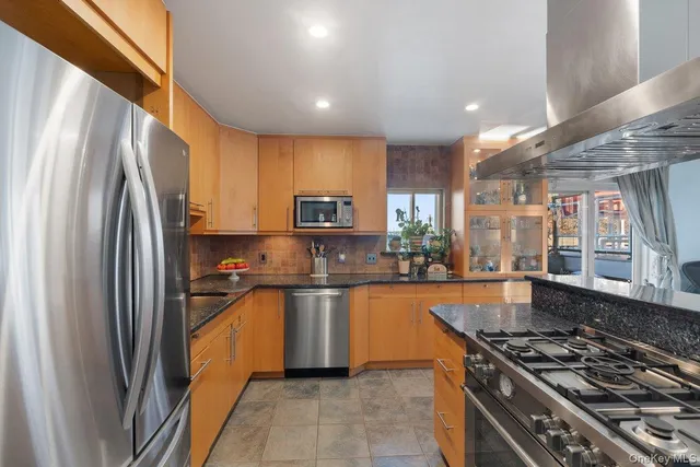 a kitchen with stainless steel appliances granite countertop a stove a sink dishwasher and a refrigerator