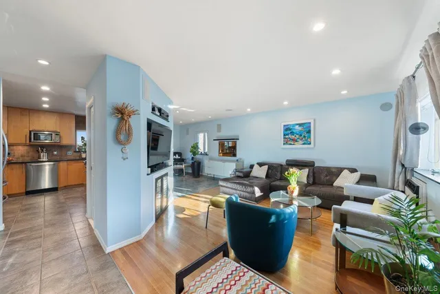 a living room with fireplace furniture and a view of kitchen