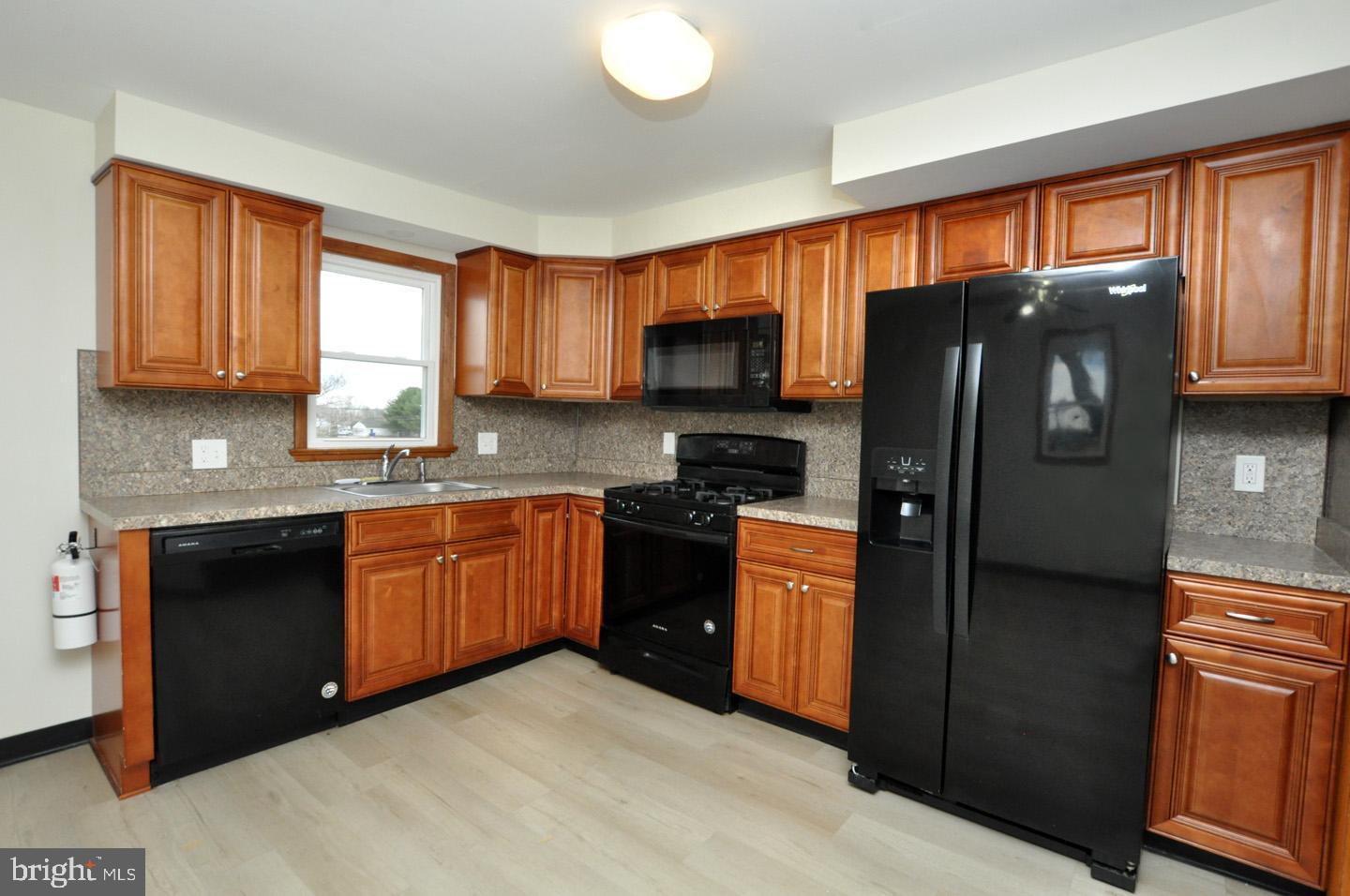 614 11th Street, Unit 2 Hammonton, NJ 08037 - Photo 10 of 12 a kitchen with granite countertop a refrigerator stove top oven a sink and dishwasher