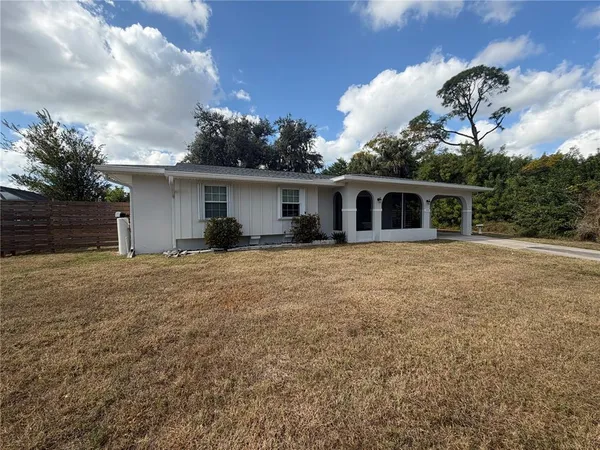 a front view of house with yard and trees in the background