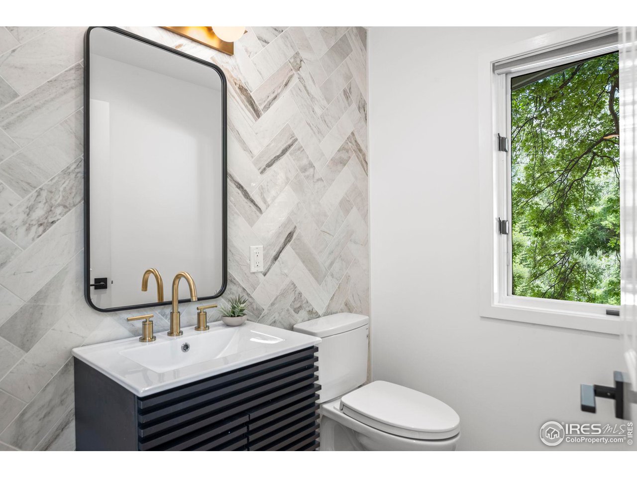 710 Willowbrook Road Boulder, CO 80302 - Photo 14 of 32 a bathroom with a sink a toilet a mirror and window