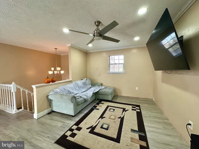 a living room with a bed furniture and a flat screen tv