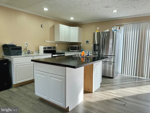 a kitchen with refrigerator a sink and cabinets