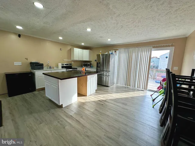 a kitchen with stainless steel appliances kitchen island granite countertop a stove and a refrigerator