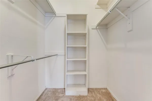 a view of walk in closet with empty racks