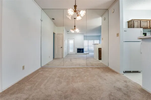 a view of a livingroom with a chandelier fan and kitchen view
