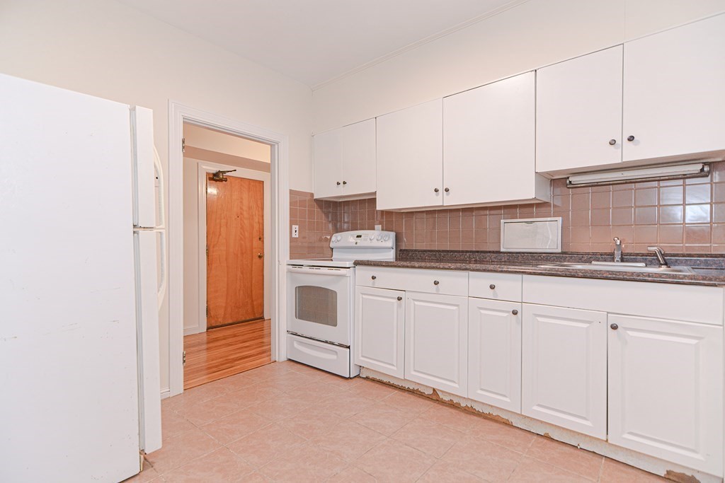 23 Warwick Road, Unit BF Brookline, MA 02445 - Photo 3 of 33 a kitchen with granite countertop white cabinets and white appliances