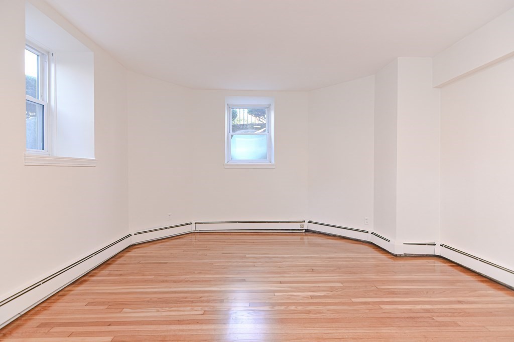 23 Warwick Road, Unit BF Brookline, MA 02445 - Photo 6 of 33 a view of an empty room with wooden floor and a window