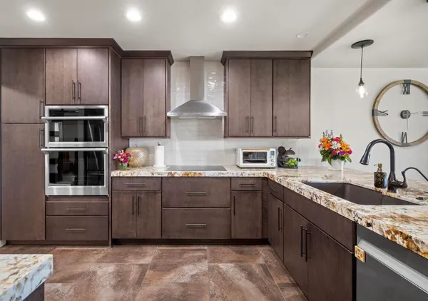 a kitchen with kitchen island granite countertop a sink and cabinets