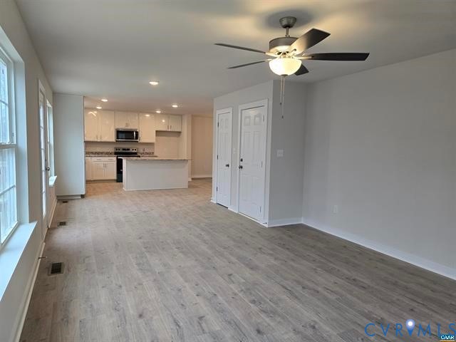 1337 Salem Church Road Palmyra, VA 22963 - Photo 5 of 21 a view of a livingroom with a kitchen island wooden floor and a ceiling fan