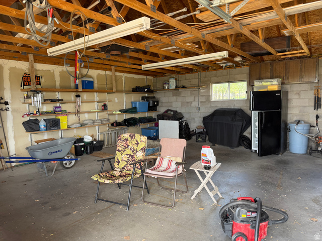 1043 East 4000th Street South Vernal, UT 84078 - Photo 11 of 31 Open garage space featuring exposed wooden ceiling rafters and concrete flooring
