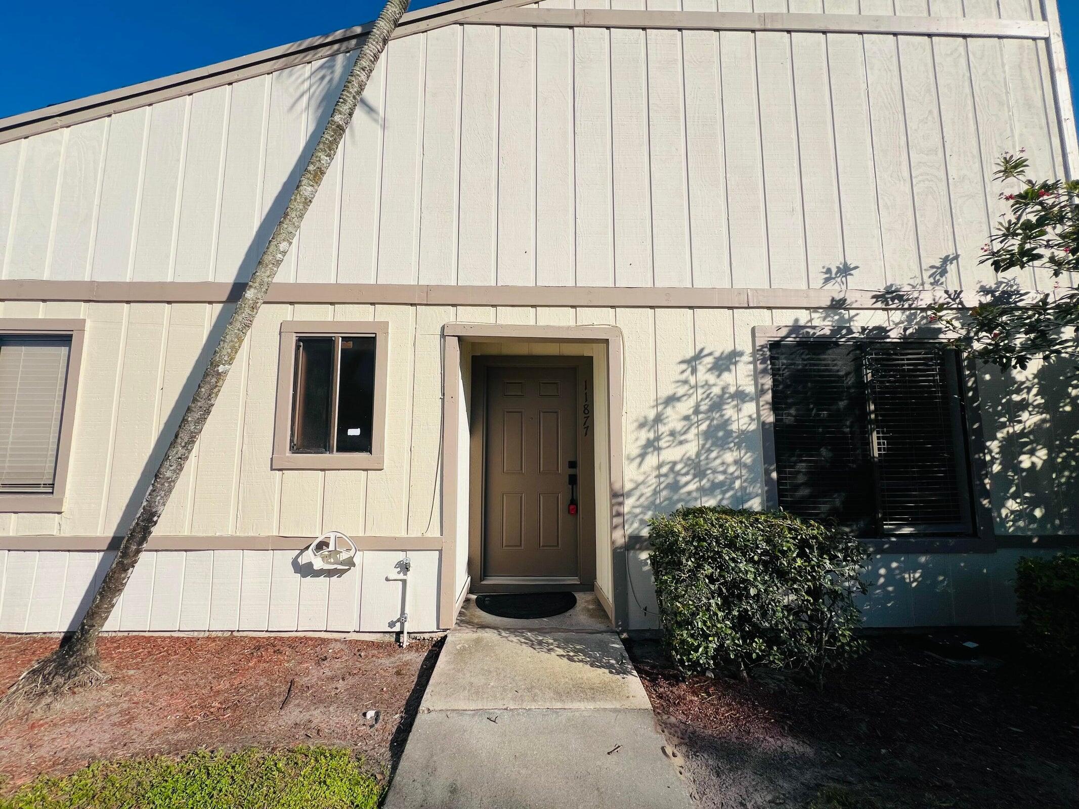 11877 Sturbridge Lane Wellington, FL 33414 - Photo 18 of 20 a front view of a house with a garden