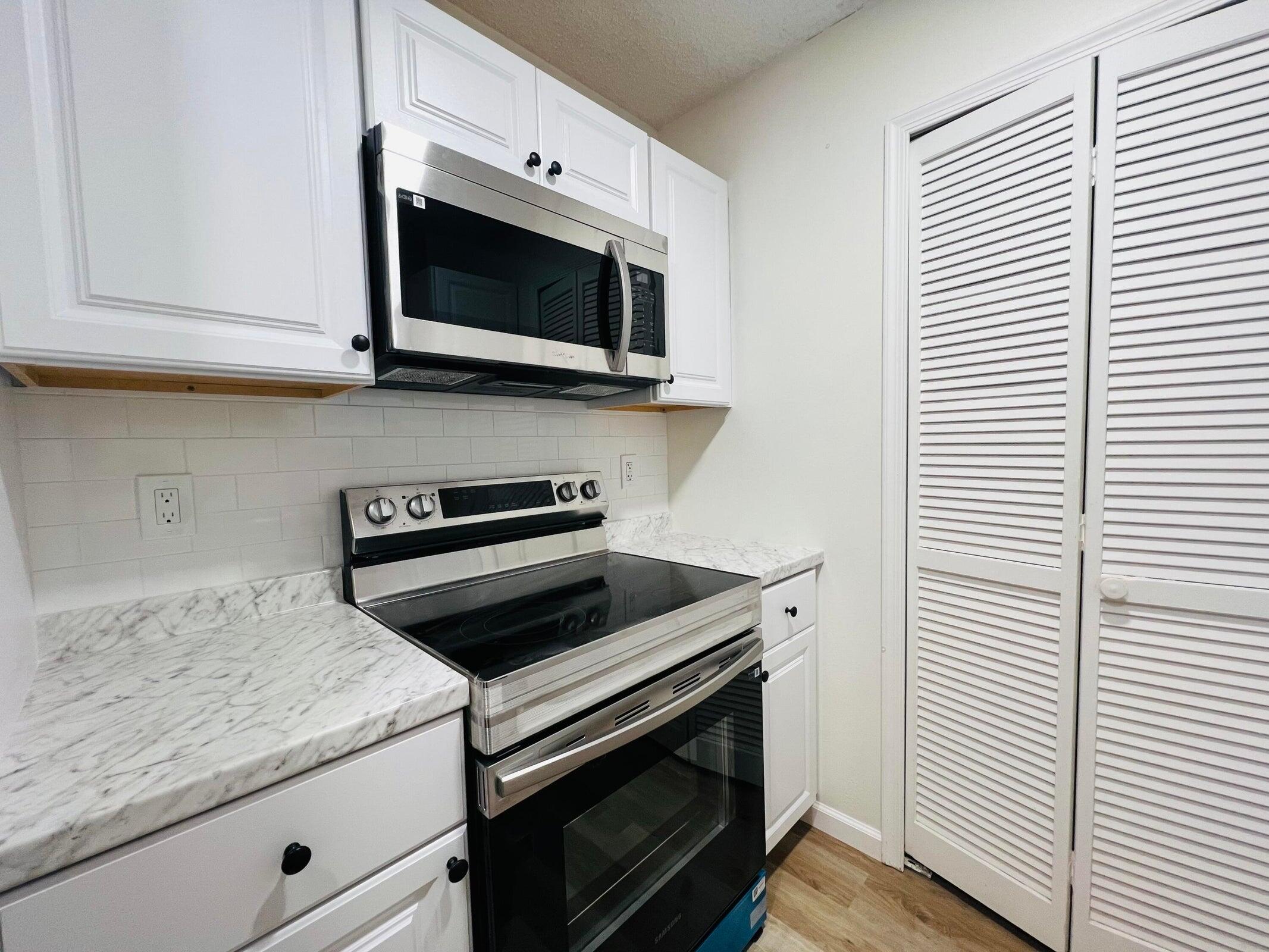 11877 Sturbridge Lane Wellington, FL 33414 - Photo 3 of 20 a kitchen with a stove and a microwave