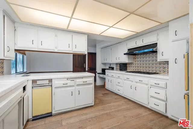 a kitchen with granite countertop white cabinets and white appliances