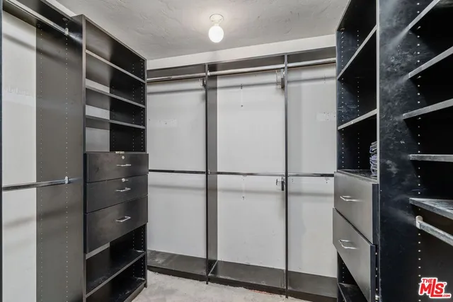 a view of walk in closet with empty racks