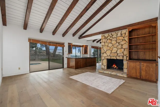 a view of an empty room with a fireplace and a couch