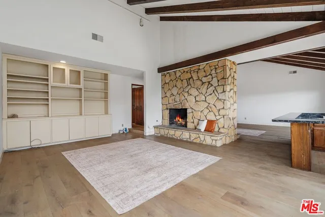 an empty room with windows and fireplace