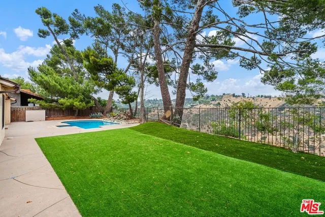 a view of yard with grass and a large tree