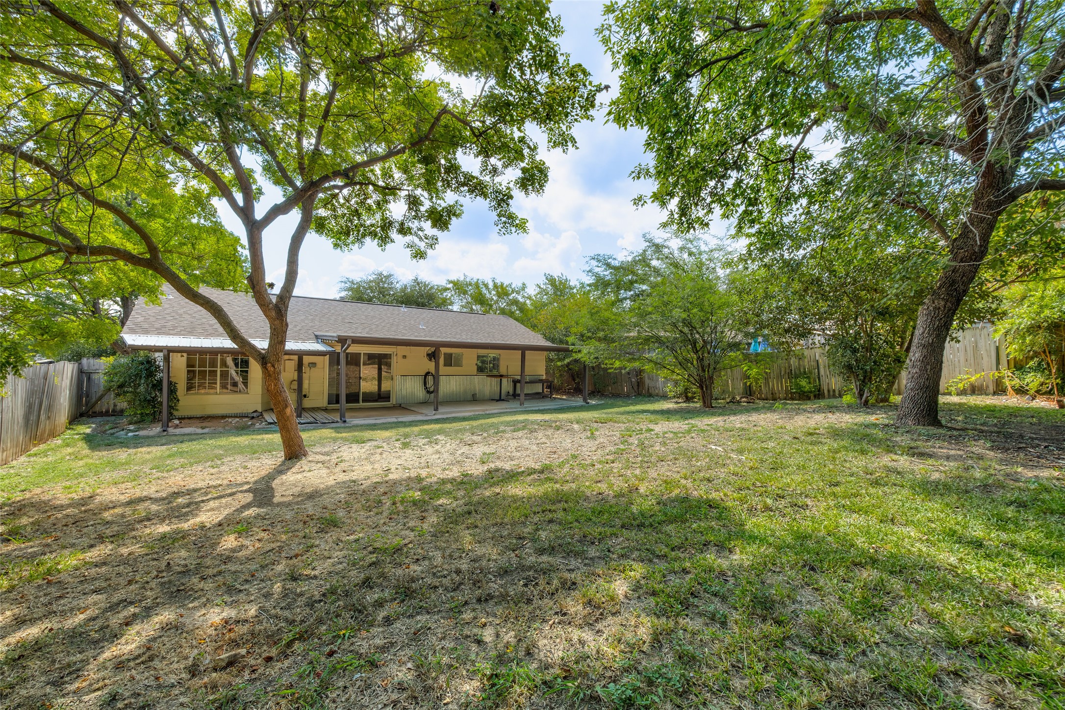 7506 Glenhill Road Austin, TX 78752 - Photo 20 of 20 A spacious, tree-shaded private yard complements the home's inviting rear patio, perfect for outdoor relaxation.