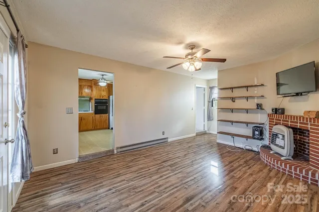 a view of a livingroom with furniture a ceiling fan and wooden floor