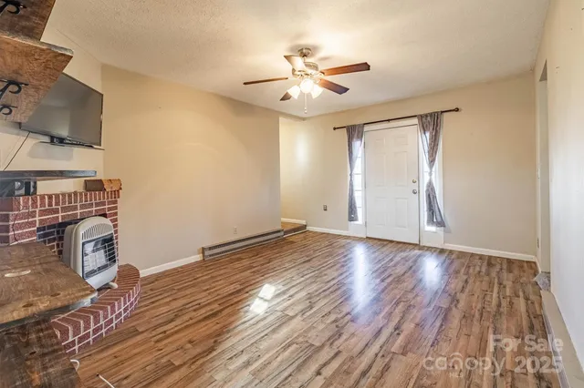 a view of a livingroom with wooden floor and a ceiling fan